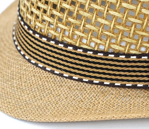Detail of breathable hollow-out straw weave and striped decorative ribbon on summer sun hat