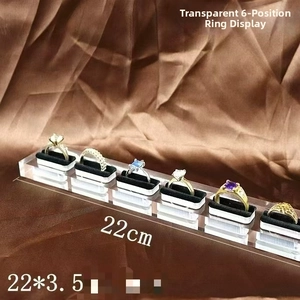 Detailed view of clear acrylic ring display stand with 6 black velvet slots for jewelry