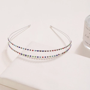 Sparkling double-layered rhinestone headband on a display stand for elegant hair styling