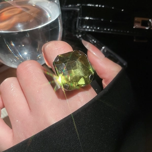 Close-up of a bold square green emerald ring with silver爪镶 claw setting on a finger