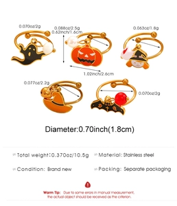 Detalle de anillos de Halloween en acero dorado con motivos de fantasma, calabaza y murciélago