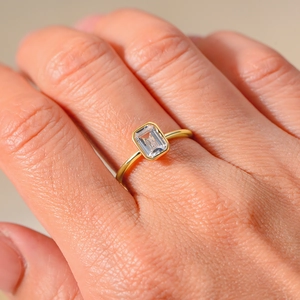 Elegant gold S925 silver ring featuring a rectangular emerald cut zircon on a finger