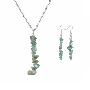 Detailed shot of handmade necklace and earrings set featuring blue-green natural raw stones