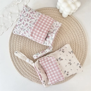 Macro detail of floral nurse pen pouch with pink gingham flap and adjustable strap