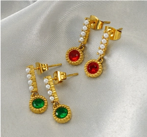 Detail of vintage gold-tone drop earrings with white pearls and red and green gemstones