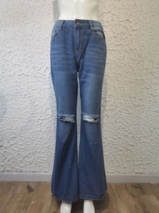 Détails d'un jean évasé bleu pour femme avec genoux déchirés et coupe décontractée en denim