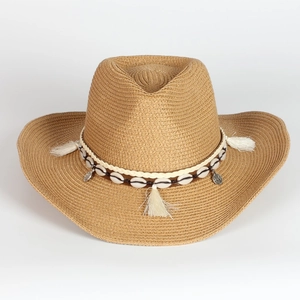 Brown straw cowboy hat with shell band and fringe tassels on a white background