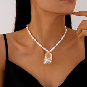 Close-up of shell pendant and freshwater pearls on model neck for ocean style