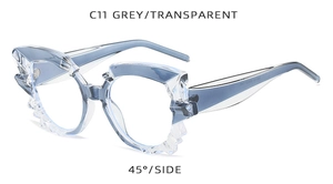 Detail view of grey transparent cat-eye sunglasses with irregular jagged frame edges