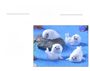 Detailed view of four cute miniature white resin sea lion figurines for micro landscapes