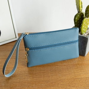 Blue litchi texture PU leather double zipper clutch bag with wristlet on wooden table