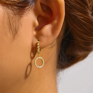 Close-up of elegant gold hoop earrings with 5A zircon pavé setting on a female model