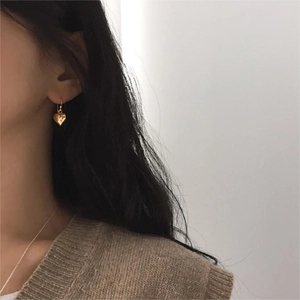 Elegant 925 sterling silver heart dangle earrings in gold finish on a female model