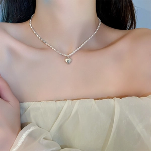 Detailed view of silver beaded double-layer heart necklace on model's neck