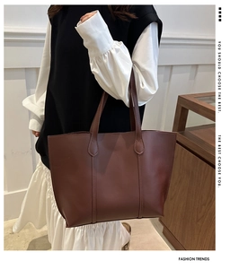 Detail of leaf-shaped stitching on the handle of this large brown leather tote bag