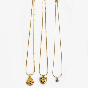 Detailed close-up of bohemian gold-plated necklaces with shell, heart, and flower pendants