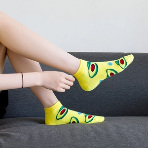 Vibrant yellow low-cut socks featuring a cute green avocado print and ribbed cotton cuffs