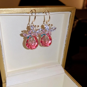 Gros plan de boucles d'oreilles cristal rose avec papillon bleu et violet dans un coffret