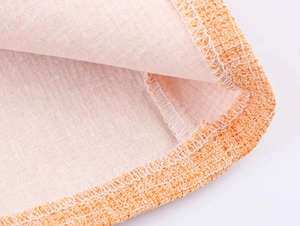 Détail du tissage en tweed orange avec couture de bord fine et doublure rose clair