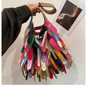 Detail of colorful bohemian fringe bag with layered leather tassels and brown handles