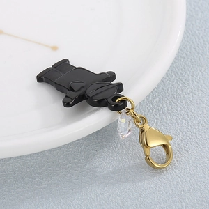 Creative black bear pendant with gold lobster clasp and zircon accent on white plate