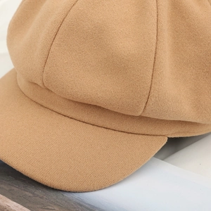 Detailed macro view of the khaki wool felt fabric and reinforced brim of the newsboy cap