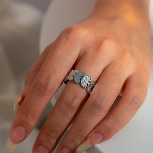 Close-up of a silver hollow leaf ring made of stainless steel worn on a model's finger