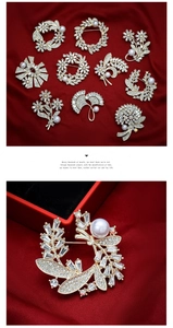 Detailed view of elegant gold leaf brooch with white pearl and sparkling rhinestones