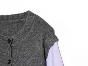 Detalle de cárdigan de punto gris oscuro con mangas acanaladas moradas y botones negros