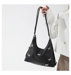 Close-up of black nylon shoulder bag with decorative silver butterfly hardware