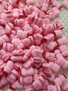 Close-up of pink pig silicone cable protectors with Good Morning print in a storage tray