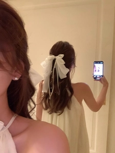 Vue arrière d'une pince à cheveux avec nœud en organza blanc et rubans