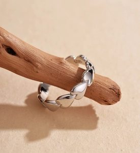 Close-up of S925 sterling silver heart ring displayed on a natural wooden stand