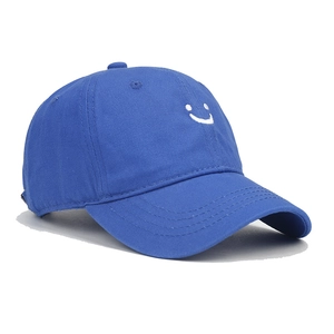 Detail of bright blue cotton baseball cap with white smiling face embroidery