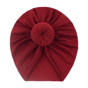 Close-up of soft cotton baby donut turban hat in burgundy with a stylish circular knot