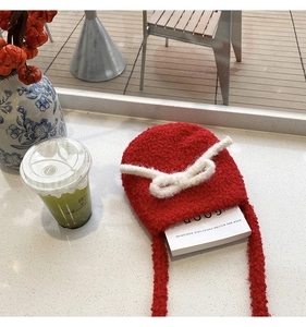 Detail of red plush bucket bag with white knit bow and books inside for daily storage