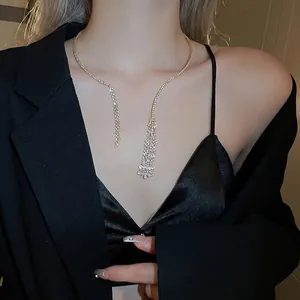 Elegant silver tassel necklace with rhinestones worn by model on black suit background