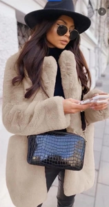 Détail de la veste en fausse fourrure de lapin avec sac à main élégant à motif crocodile noir
