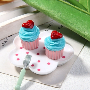 Close-up of resin cupcake miniatures with pink polka dot tray and green fork for DIY craft