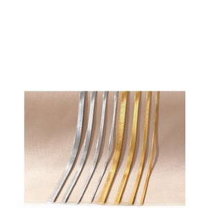 Nahaufnahme von flachen Schlangenketten aus Gold und Silber in verschiedenen Breiten