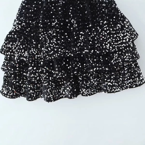 Abito nero smanicato alla moda con paillettes d'argento e volant a più strati