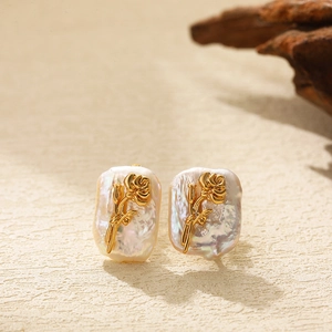 Detailed close-up of golden rose flower earrings on baroque pearl base with vintage charm
