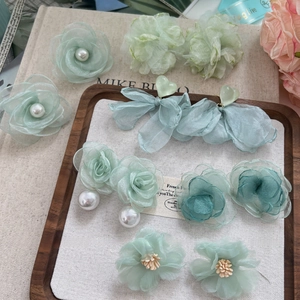 Boucles d'oreilles fleurs avec pétales vert menthe, perles d'imitation et pompons