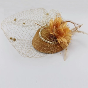 Detailed close-up of golden fascinator hat with mesh veil, fabric flower and feathers