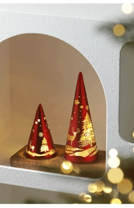 Close-up of red and gold glass Christmas tree lamps with warm LED lights and reindeer patterns