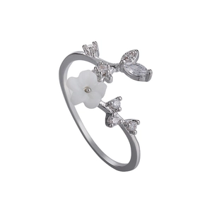 Silver flower ring with white shell petals and sparkling zircon leaves on a white background