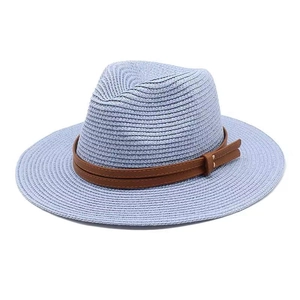 Détail d'un chapeau de paille bleu clair avec deux lanières en cuir marron