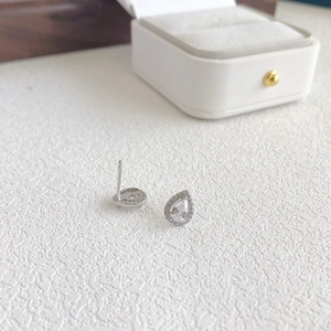 Macro shot of silver teardrop stud earrings with pave-set sparkling zircon crystals