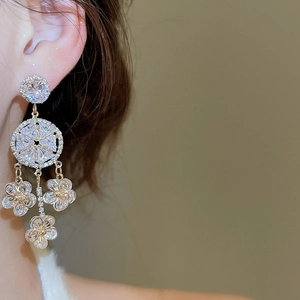 Close-up of zircon flower tassel earrings worn on ear with elegant layered crystal design