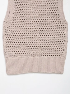 Detailed macro view showing hollow knit texture and ribbed hem of the beige vest
